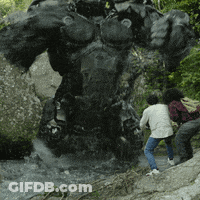 A Group Of People Are Standing In Front Of A Large Statue GIF