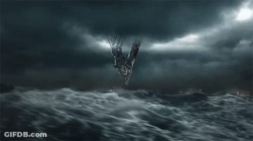 A Group Of People Are Standing In Front Of A Large Wave In The Ocean At Night . GIF