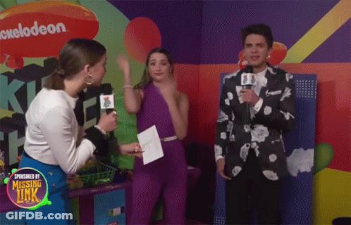 A Group Of People Are Standing In Front Of A Nickelodeon Logo GIF