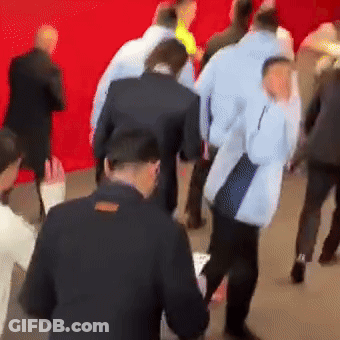 A Group Of People Are Standing In Front Of A Red Background GIF