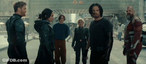 Group Standing In Front Of Sign A GIF
