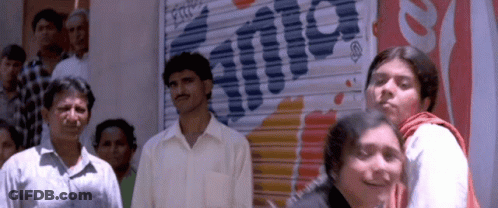A Group Of People Are Standing In Front Of A Sign That Says Fanta GIF