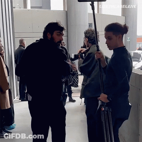 A Group Of People Are Standing In Front Of A Sign That Says Lizeth La Selene GIF