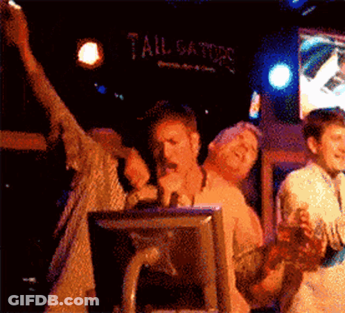 A Group Of People Are Standing In Front Of A Sign That Says Tailgate GIF