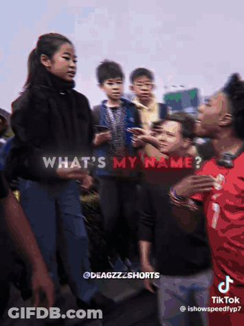 A Group Of People Are Standing In Front Of A Sign That Says What 'S My Name On It GIF