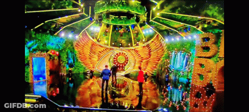 A Group Of People Are Standing In Front Of A Stage That Has A Big B On It GIF