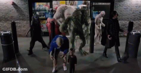 A Group Of People Are Standing In Front Of A Store With Monsters Coming Out Of The Door . GIF