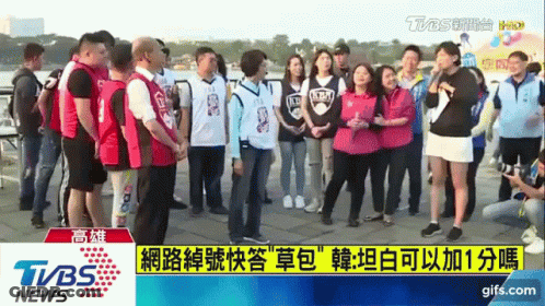 A Group Of People Are Standing In Front Of A Tvbs News Screen GIF