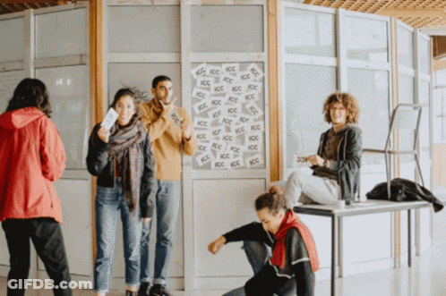 A Group Of People Are Standing In Front Of A Wall That Has A Lot Of Ice Written On It GIF