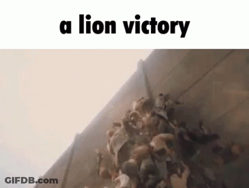 A Group Of People Are Standing In Front Of A Wall With The Words `` A Lion Victory '' Written On It . GIF