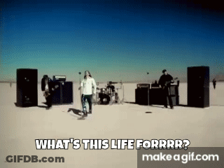 A Group Of People Are Standing In The Middle Of A Desert In Front Of Speakers . GIF