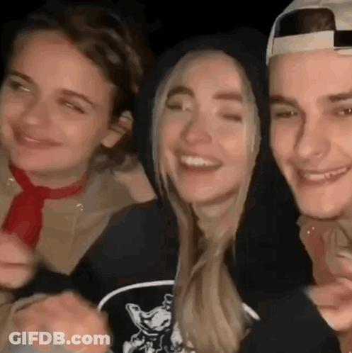 A Group Of People Are Standing Next To Each Other And Smiling For The Camera . GIF