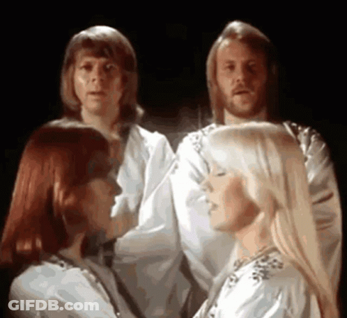A Group Of People Are Standing Next To Each Other In A Dark Room And Singing . GIF