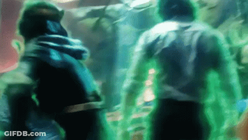 A Group Of People Are Standing Next To Each Other In A Dark Room With Green Lights Coming Out Of Their Bodies . GIF