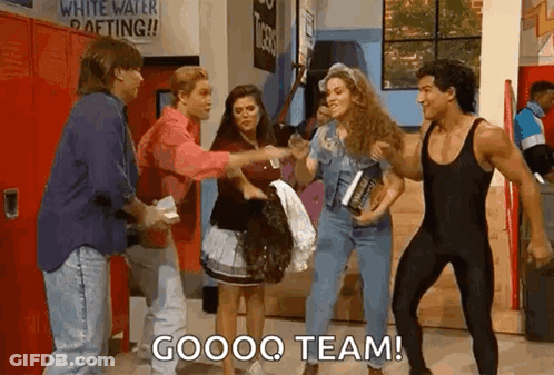 A Group Of People Are Standing Next To Each Other In A Hallway And One Of Them Is Holding A Book . GIF