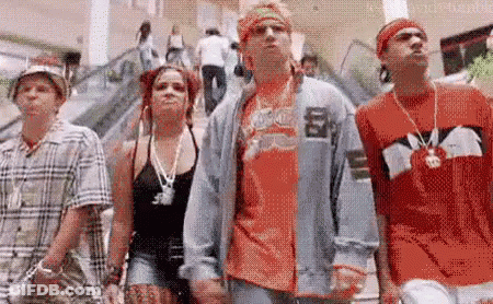 A Group Of People Are Standing Next To Each Other In A Mall . GIF