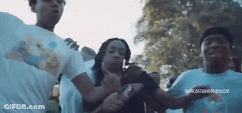 A Group Of People Are Standing Next To Each Other In A Park And Dancing . GIF