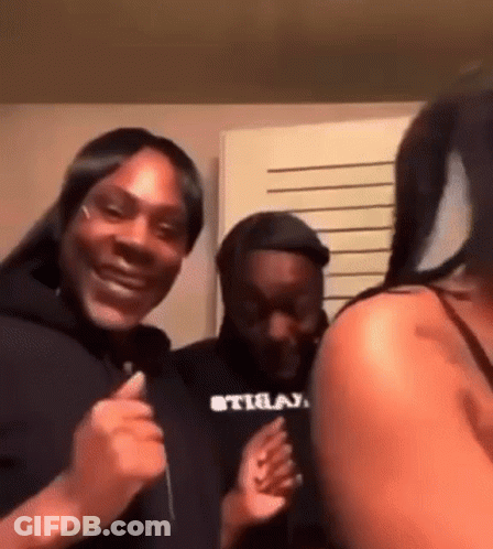 A Group Of People Are Standing Next To Each Other In A Room And Laughing . GIF