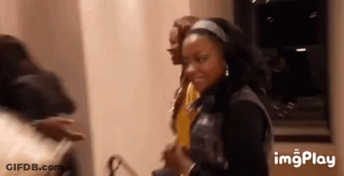 A Group Of People Are Standing Next To Each Other In A Room And Smiling . GIF