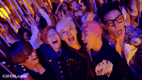 A Group Of People Are Standing Next To Each Other In A Room Laughing . GIF