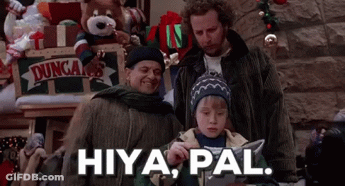 A Group Of People Are Standing Next To Each Other In A Room With Christmas Decorations . GIF