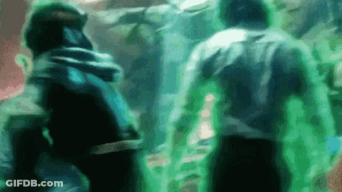 A Group Of People Are Standing Next To Each Other In A Room With Green Lights . GIF