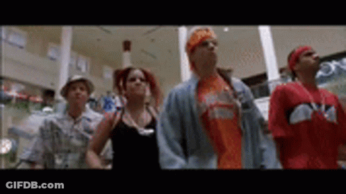 A Group Of People Are Standing Next To Each Other In A Shopping Mall . GIF
