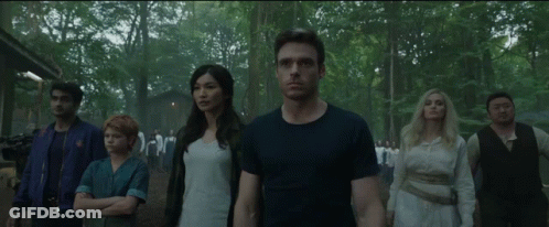 A Group Of People Are Standing Next To Each Other In The Woods GIF