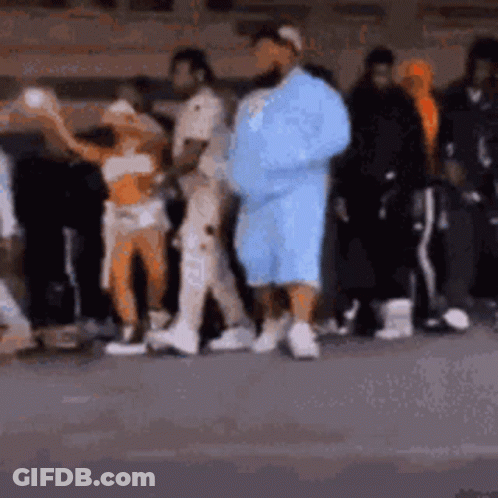 A Group Of People Are Standing Next To Each Other On The Street . GIF