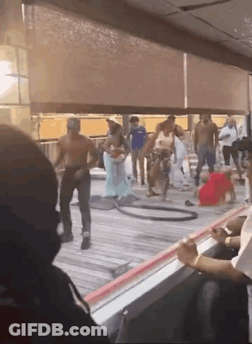 A Group Of People Are Standing On A Deck With A Hula Hoop GIF