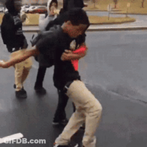 A Group Of People Are Standing On A Street . GIF