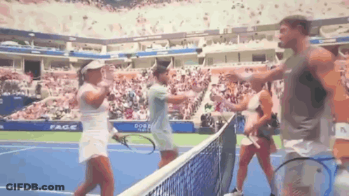 A Group Of People Are Standing On A Tennis Court With Rackets . GIF
