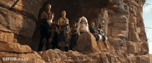 A Group Of People Are Standing On Top Of A Rock Formation GIF
