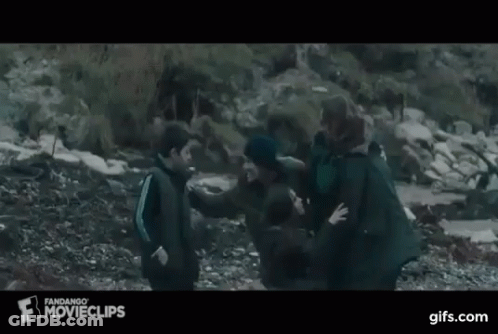 A Group Of People Are Standing On Top Of A Rocky Hill . GIF