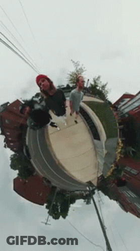 A Group Of People Are Standing On Top Of A Skateboard Ramp . GIF