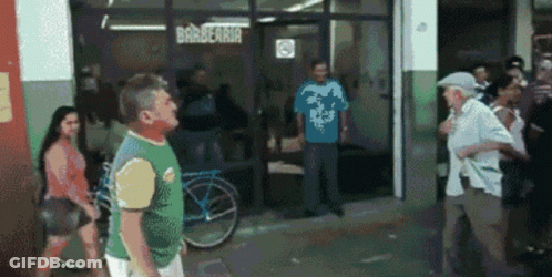 A Group Of People Are Standing Outside Of A Barbearia GIF