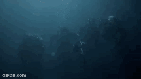 A Group Of People Are Swimming In The Ocean With Bubbles Coming Out Of The Water . GIF