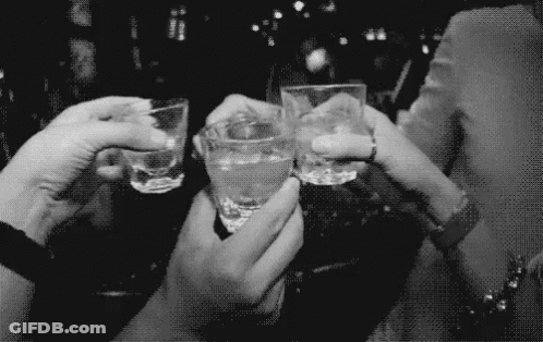 A Group Of People Are Toasting With Shot Glasses In Their Hands GIF