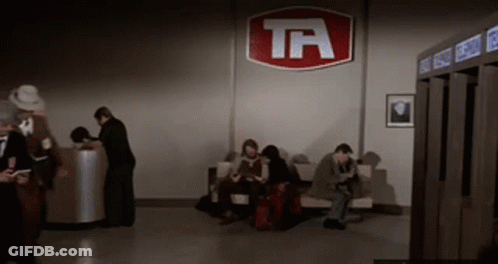 People Waiting In Room With TA Sign GIF