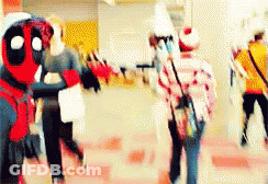 A Group Of People Are Walking Down A Hallway And One Of Them Is Dressed In A Deadpool Costume . GIF