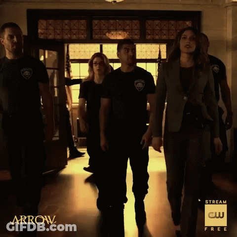 A Group Of People Are Walking Down A Hallway With The Words Arrow On The Bottom GIF