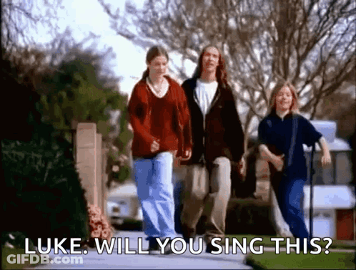 A Group Of People Are Walking Down A Sidewalk And One Of Them Is Asking Luke Will You Sing This . GIF
