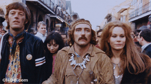 A Group Of People Are Walking Down A Street And One Of Them Has A Button On His Jacket That Says ' Freedom ' On It GIF