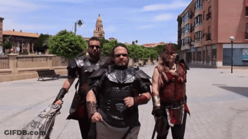 A Group Of People Are Walking Down A Street And One Of Them Is Wearing A Costume That Says ' Alianza ' GIF