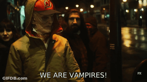 A Group Of People Are Walking Down A Street And They Are Vampires GIF