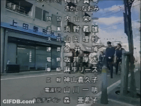 A Group Of People Are Walking Down A Street In Front Of A Building With Chinese Writing GIF