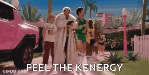 A Group Of People Are Walking Down A Street With The Words `` Feel The Keenergy '' Written On The Screen . GIF