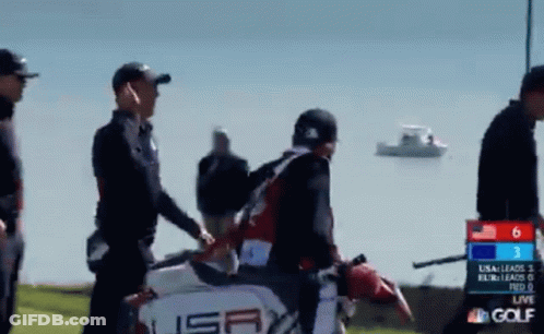 A Group Of People Are Walking On A Golf Course With A Scoreboard That Says Nbc Golf GIF