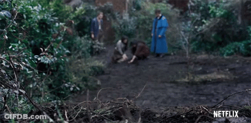 A Group Of People Are Walking Through A Forest With A Netflix Logo In The Background . GIF