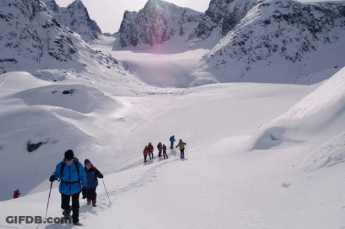 A Group Of People Are Walking Through The Snow GIF